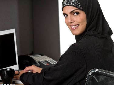 A woman wearing a headscarf studying.