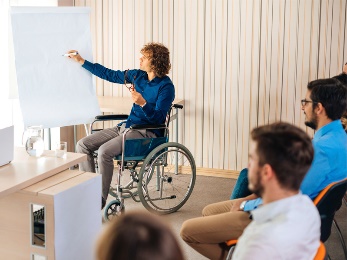 A professor in a wheelchair teaching a class.